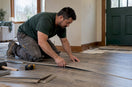 Installer fitting a floating floor in a home
